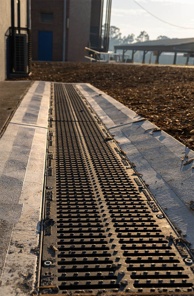 A sloped concrete surface with a cast iron drainage system installed