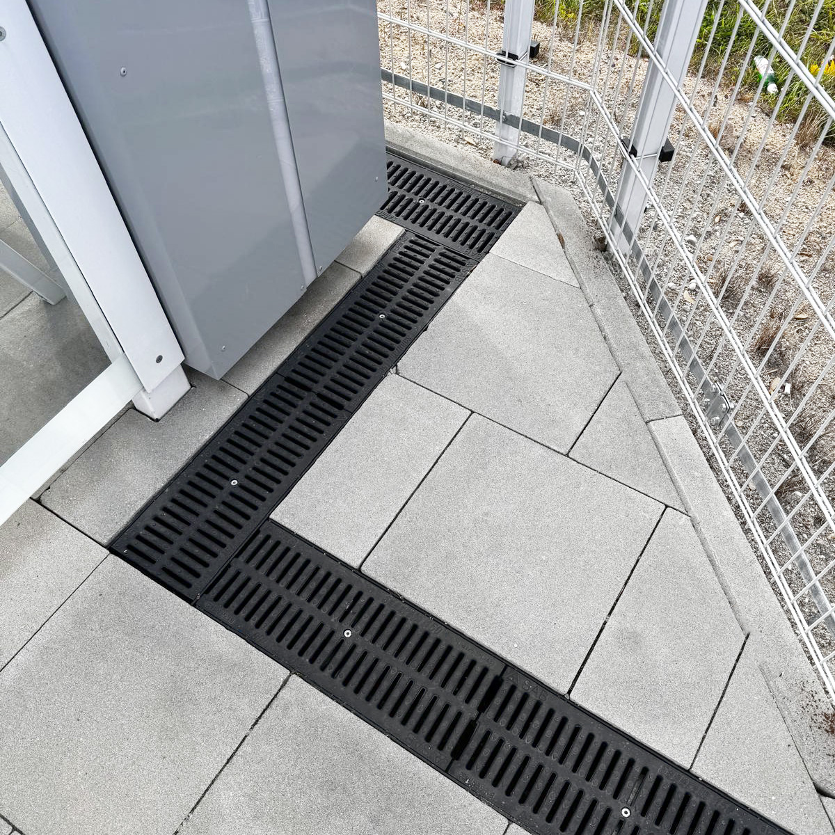drainage system with black grate installed around a corner